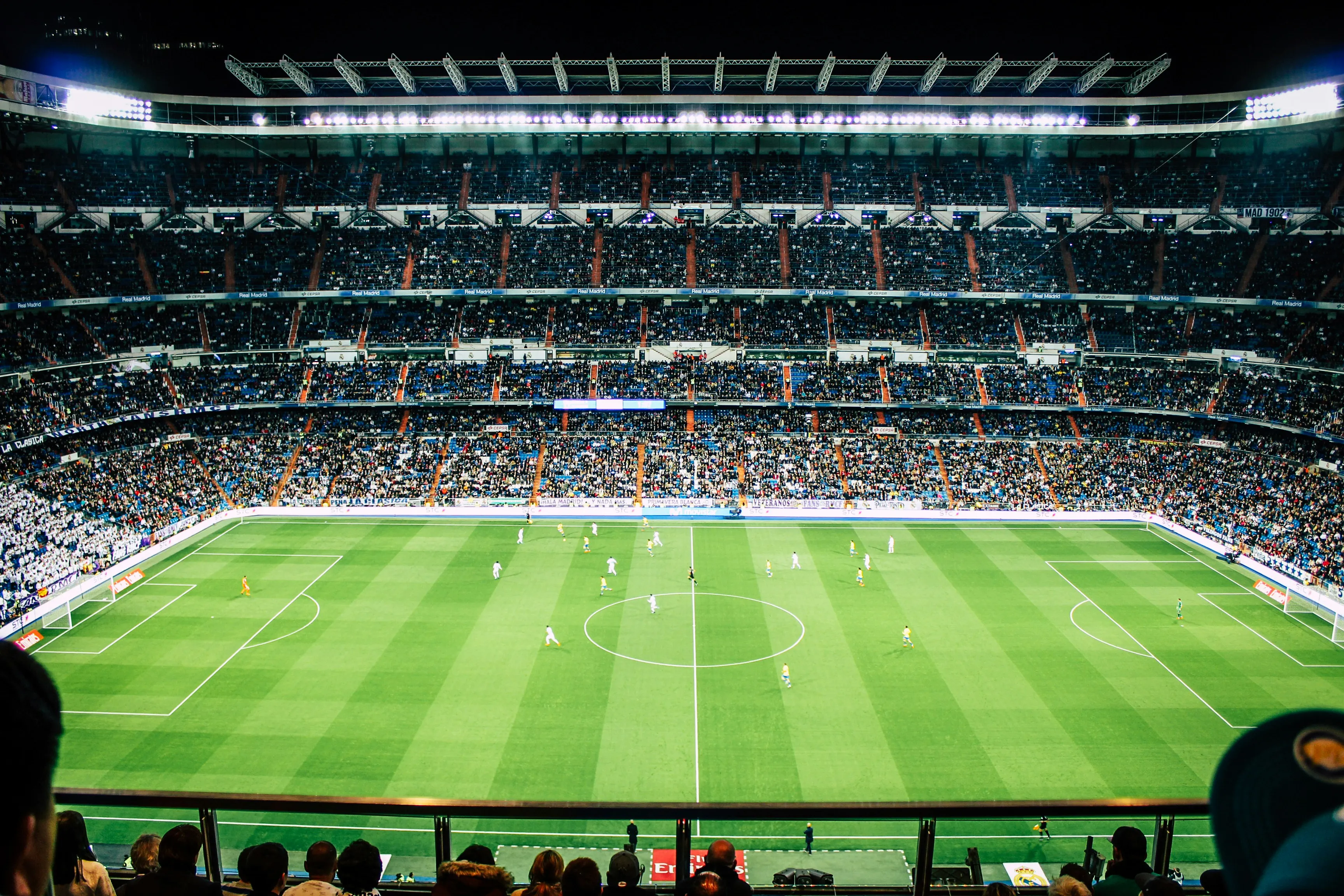 Soccer ball on the pitch under stadium lights